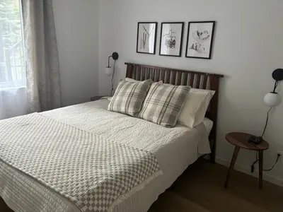 a bedroom with a bed and two pictures on the wall at Ski in out condo sur la montagne in Bromont