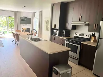 a kitchen with a sink and a stove top oven at Ski in out au pied des pentes in Bromont