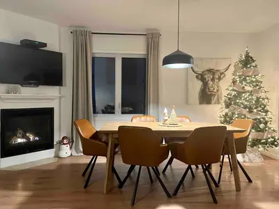 a dining room with a table and a christmas tree at Ski in out au pied des pentes in Bromont