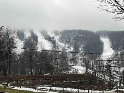 a snow covered mountain with a ski slope in the distance at Ski in out au pied des pentes in Bromont