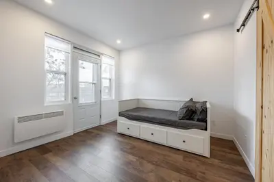 a bedroom with a bed and two windows at Séjour Coup de Cœur! Confort et emplacement idéal in Montréal