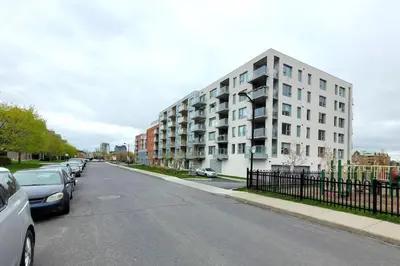 a street with cars parked in front of a building at Corporate Stays Blum 2 Bedrooms in Brossard