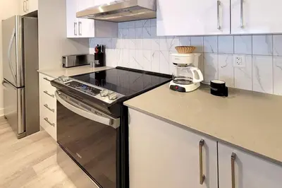 a kitchen with white cabinets and a blender on the counter at Corporate Stays Blum 2 Bedrooms in Brossard
