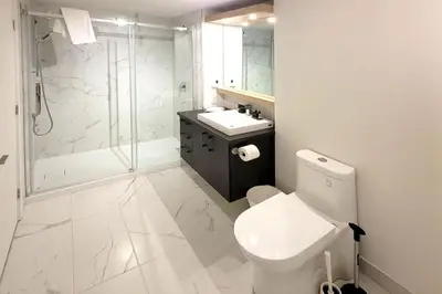 a bathroom with a toilet and a shower and a sink at Corporate Stays Blum 2 Bedrooms in Brossard