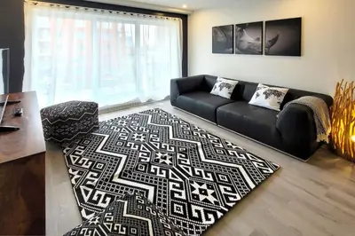 a living room with a black couch and a rug at Corporate Stays Blum 2 Bedrooms in Brossard