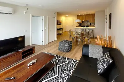 a living room with a couch and a table at Corporate Stays Blum 2 Bedrooms in Brossard