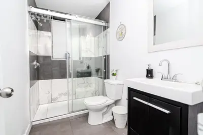 a bathroom with a shower and a toilet and a sink at Modern Apartment in Montreal in Montréal