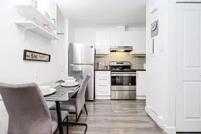 a kitchen with a table and chairs and a refrigerator at Modern Apartment in Montreal in Montréal