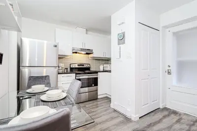 a kitchen with a table and chairs and a refrigerator at Modern Apartment in Montreal in Montréal