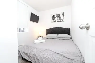 a white bedroom with a bed with two pillows at Modern Apartment in Montreal in Montréal