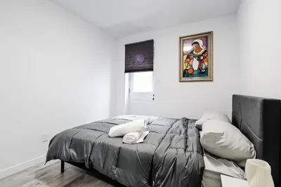 a bedroom with a bed and a painting on the wall at Appartement 2 chambres Downtown Montréal in Montréal
