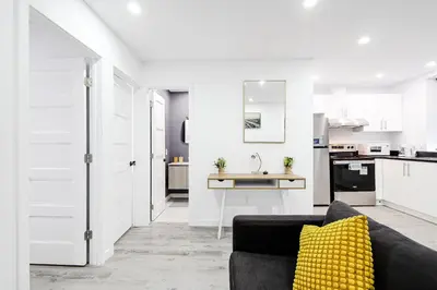 a living room with a black couch and a yellow pillow at Appartement 2 chambres Downtown Montréal in Montréal