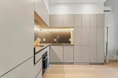 a kitchen with white cabinets and a sink at Miles by Alta in Montréal