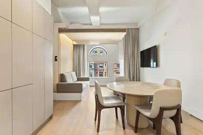 a dining room with a table and chairs and a couch at Miles by Alta in Montréal