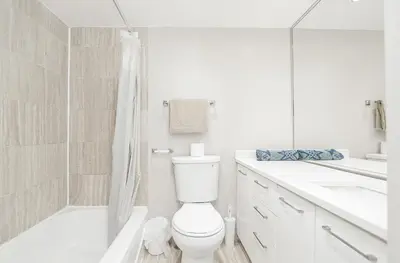 a white bathroom with a toilet and a shower at Séjour idéal au cœur de Montréal in Montréal