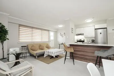 a living room with a couch and a kitchen at Séjour idéal au cœur de Montréal in Montréal