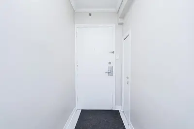 a hallway with white walls and a white door at Séjour idéal au cœur de Montréal in Montréal