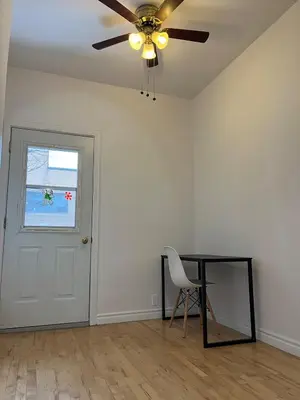 a room with a ceiling fan and a table and a chair at Urban Comfort 3BR Apartment in NDG in Montréal