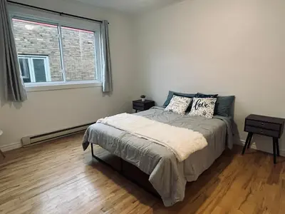 a bedroom with a bed and a window at Urban Comfort 3BR Apartment in NDG in Montréal
