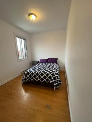 a bedroom with a bed with a black and white blanket at Urban Comfort 3BR Apartment in NDG in Montréal
