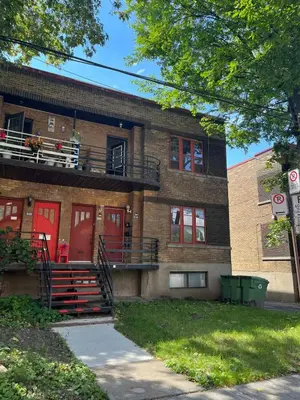a building with a balcony with a dog sitting on the porch at Urban Comfort 3BR Apartment in NDG in Montréal