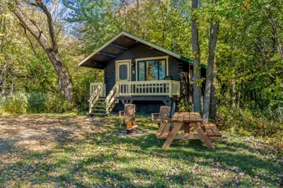 a tiny house in the woods with a picnic table at chalet 2 - Domaine de l'Archipel in Sorel