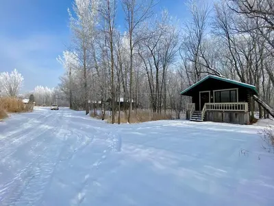 a cabin in the snow with a snow covered road at chalet 2 - Domaine de l'Archipel in Sorel