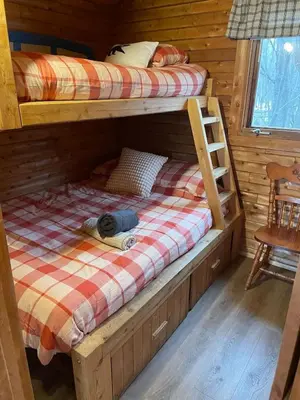a bedroom with two bunk beds in a log cabin at chalet 2 - Domaine de l'Archipel in Sorel