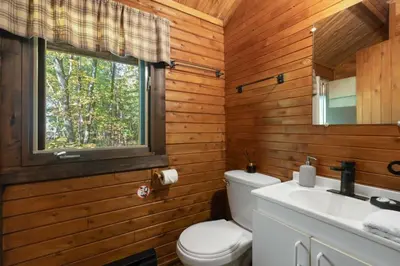 a bathroom with a toilet and a sink and a window at chalet 2 - Domaine de l'Archipel in Sorel