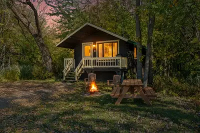 a tiny house in the woods with a camp fire at chalet 5 Domaine de l'Archipel in Sorel