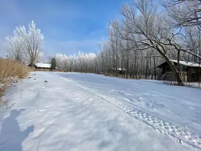 a snow covered road in front of a barn at chalet 5 Domaine de l'Archipel in Sorel