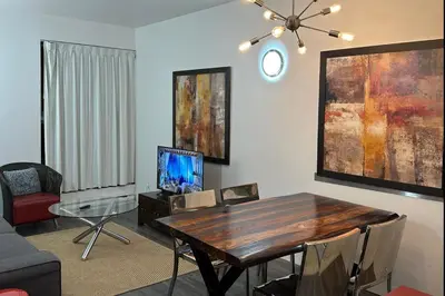 a living room with a wooden table and a dining room at Cozy Open Space in Montréal