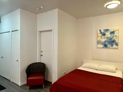 a bedroom with a red bed and a chair at Cozy Open Space in Montréal