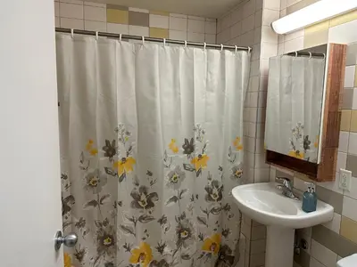 a bathroom with a shower curtain with a sink at Cozy Open Space in Montréal