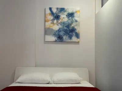 a bedroom with a bed with a painting on the wall at Cozy Open Space in Montréal