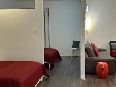 a room with a bed and a couch and a mirror at Cozy Open Space in Montréal