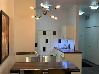 a kitchen with a wooden table and chairs and a chandelier at Cozy Open Space in Montréal