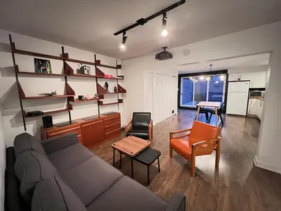 a living room with a couch and a table at Appartement Mid Century 2 Chambres avec Jardin in Montréal