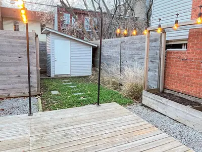 a wooden walkway in a yard with a fence at Appartement Mid Century 2 Chambres avec Jardin in Montréal