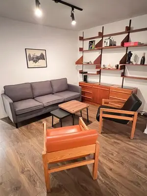 a living room with a couch and a table at Appartement Mid Century 2 Chambres avec Jardin in Montréal
