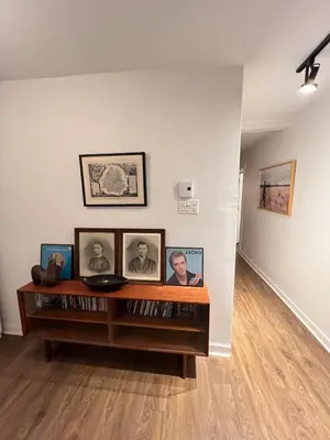 a room with a shelf with pictures on the wall at Appartement Mid Century 2 Chambres avec Jardin in Montréal