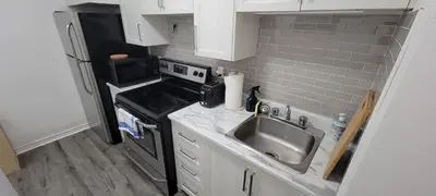 a small kitchen with a sink and a stove at Comfortable condo in Montreal in Montréal