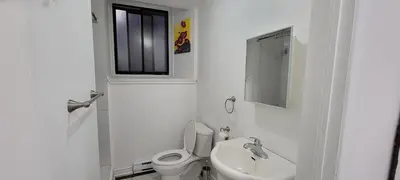 a white bathroom with a toilet and a sink at Comfortable condo in Montreal in Montréal