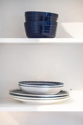 a stack of plates and a bowl on a shelf at Appartement au centre de Montréal in Montréal