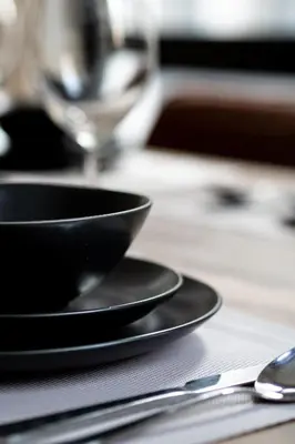 a black bowl and plate on a table with a spoon at Charmant appartement au vieux port de Montréal in Montréal