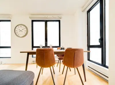 a dining room with a table and two chairs and a clock at Charmant appartement au vieux port de Montréal in Montréal