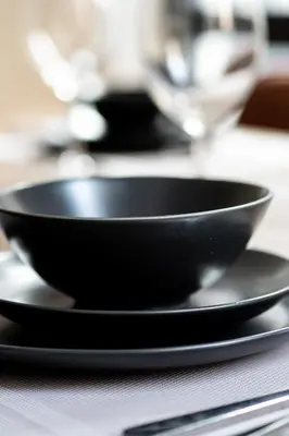 a black bowl on top of two plates on a table at Charmant appartement au vieux port de Montréal in Montréal