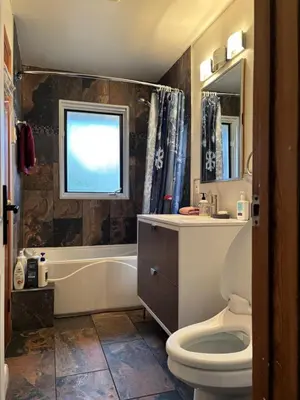 a bathroom with a toilet and a tub and a sink at Entire floor in a Spacious bungalow ensuite close to beach and train in Pincourt