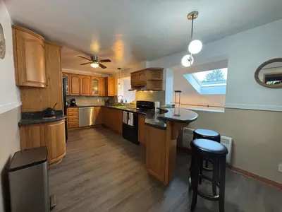 a kitchen with wooden cabinets and a counter top at Entire floor in a Spacious bungalow ensuite close to beach and train in Pincourt