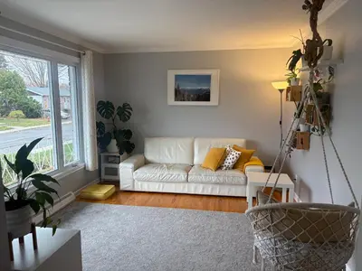 a living room with a white couch and a window at Escapade familiale à Longueuil in Longueuil